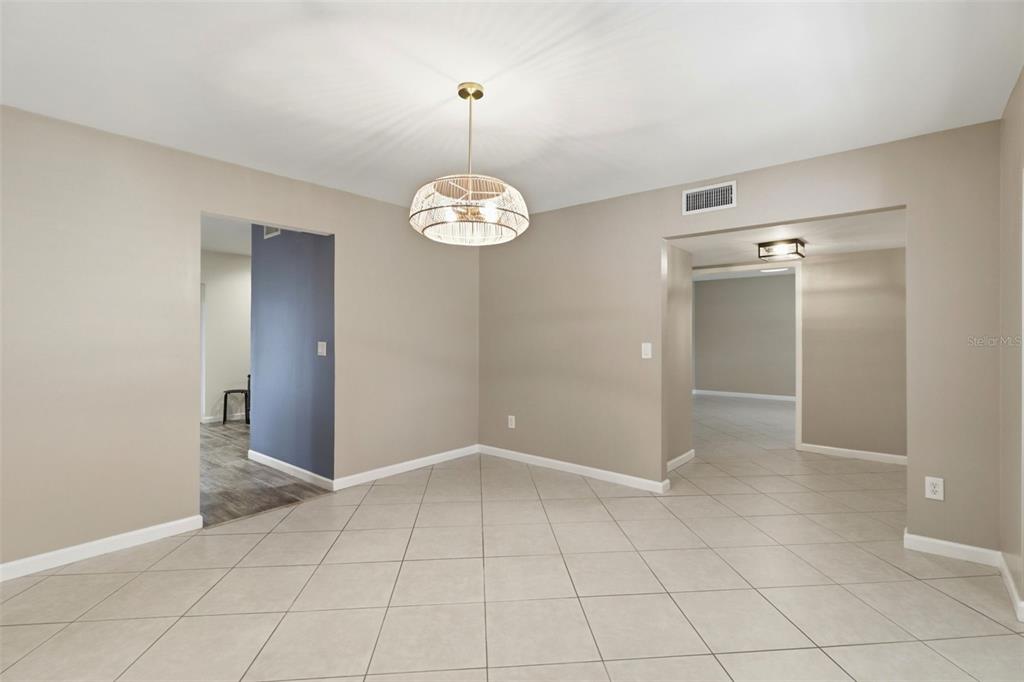 A dining area with beige walls, tile flooring, and a decorative pendant light fixture — 302 BLOOMINGFIELD DRIVE, BRANDON, FL