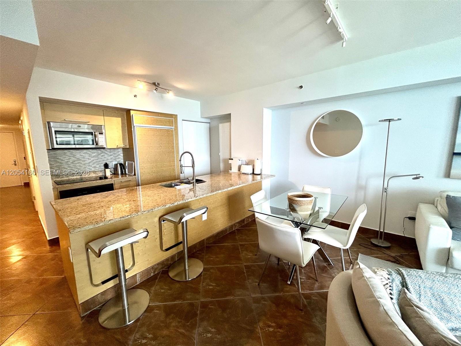A kitchen with granite countertops and a dining area with a glass table — 1830 S Ocean Dr # 3309, Hallandale Beach FL 33009, HALLANDALE BEACH, FL