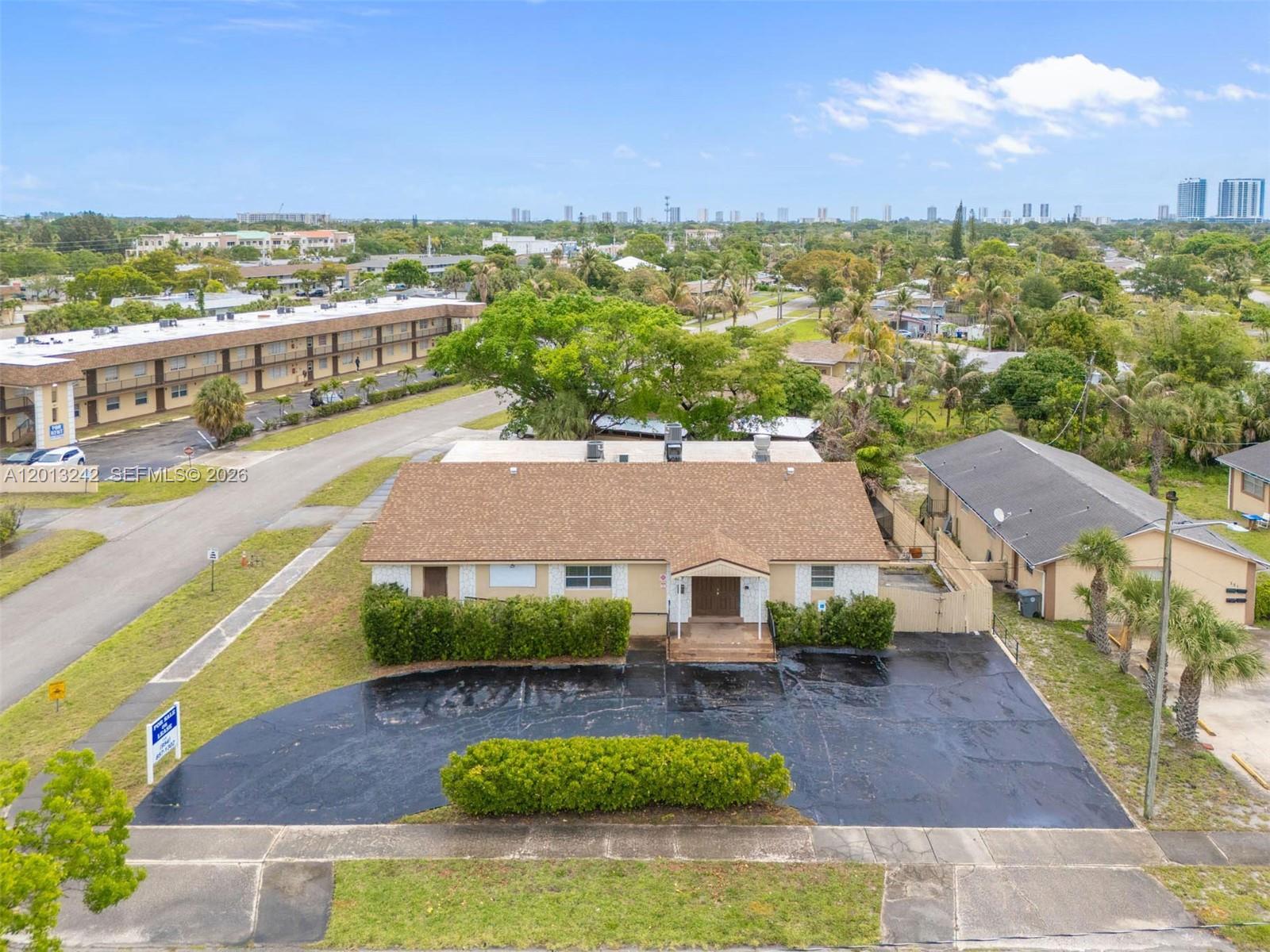 An aerial view shows a single-story building with a brown roof and a paved parking lot — 359 10th St, Lake Park FL 33403, LAKE PARK, FL