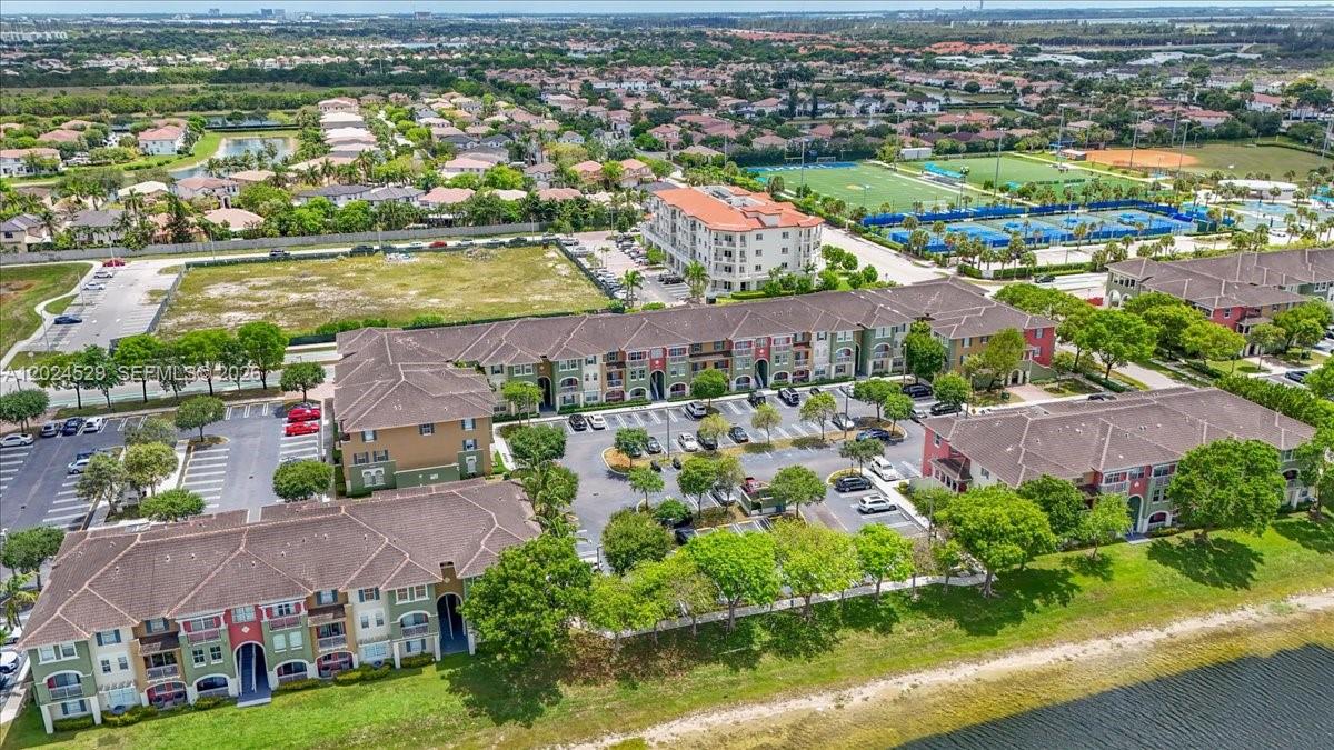 An aerial view shows multi-story apartment buildings with parking lots, green spaces, and a lake — 11102 NW 83rd St # 108, Doral FL 33178, DORAL, FL