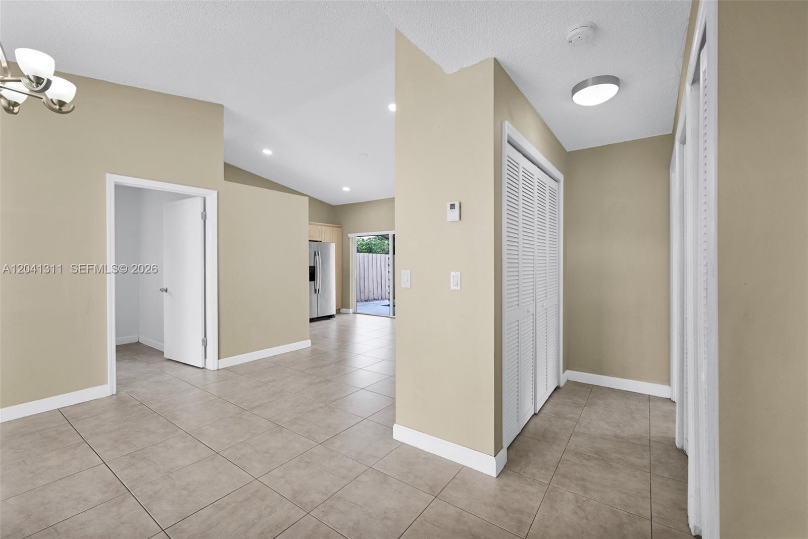 A tiled entryway leads to a living area with a kitchen and sliding glass doors — 4471 SW 138th Ct, Miami FL 33175, MIAMI, FL