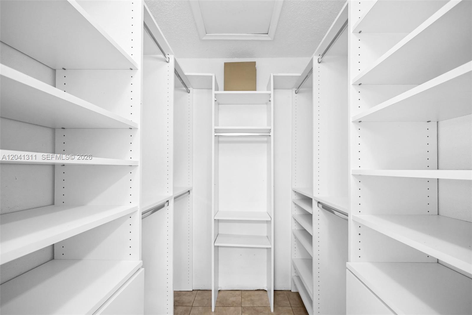 A walk-in closet features white shelving units, hanging rods, and tiled flooring — 4471 SW 138th Ct, Miami FL 33175, MIAMI, FL