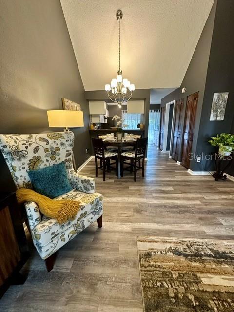 A living area with a patterned armchair leads to a dining space under a chandelier — 4833 MYRTLE OAK DRIVE UNIT 25, NEW PORT RICHEY, FL