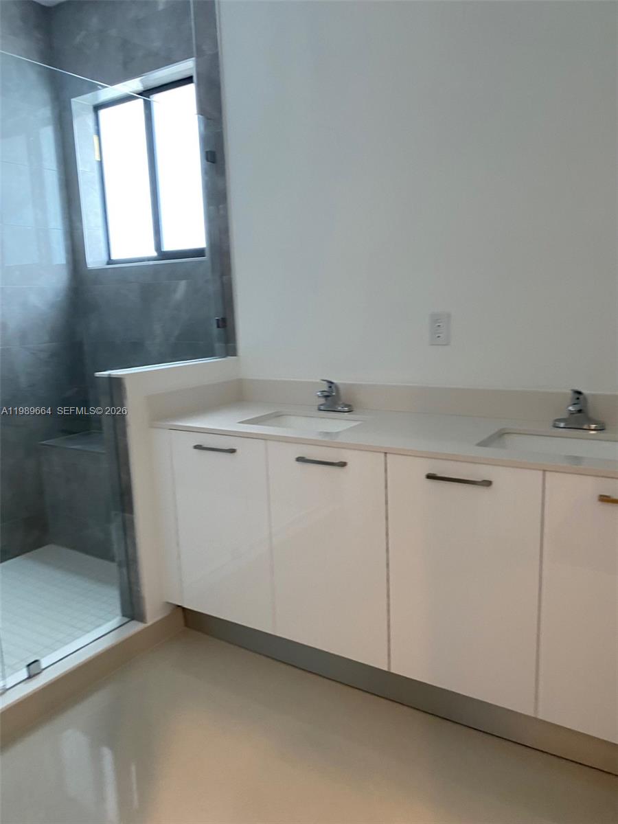 A modern bathroom features a double-sink vanity with white cabinets and a glass-enclosed shower — 13633 SW 157th Pl # 0, Miami FL 33196, MIAMI, FL