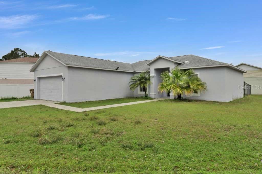 A single-story gray house with a two-car garage and a front walkway — 820 GRANTHAM DRIVE, KISSIMMEE, FL