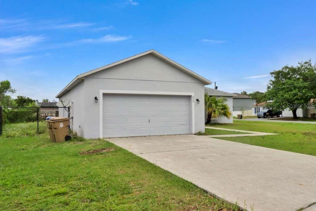 A light gray house features a single-car garage and a concrete driveway — 820 GRANTHAM DRIVE, KISSIMMEE, FL