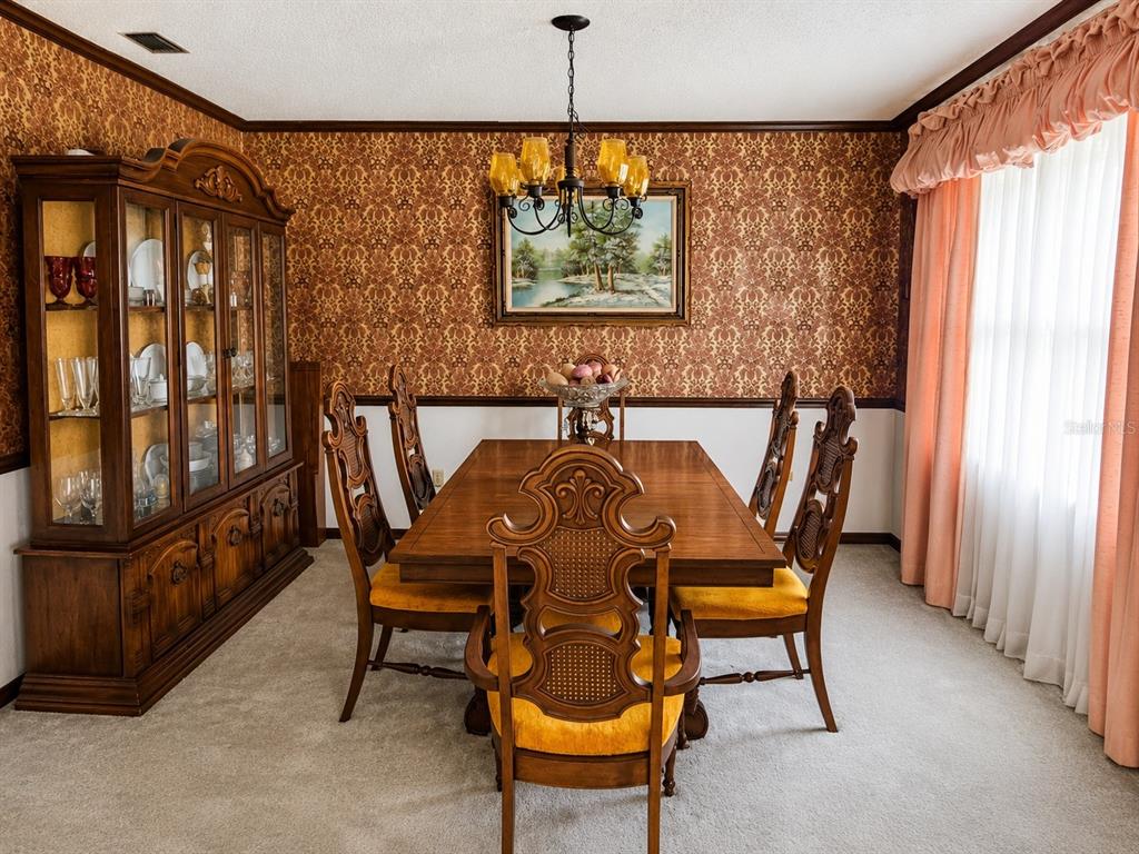 A dining room features a wooden table and chairs, a china cabinet, and patterned wallpaper — 4303 KANDRA COURT, ORLANDO, FL