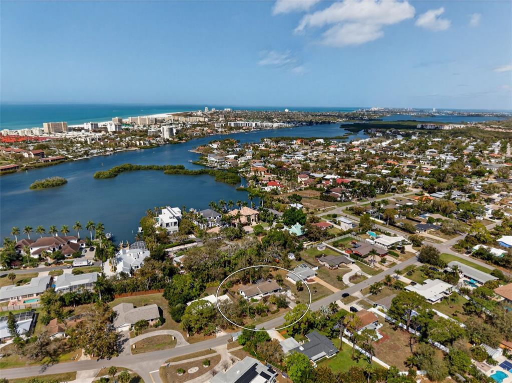 An aerial view shows a residential neighborhood with a circled house near a bay — 6338 BEECHWOOD AVENUE, SARASOTA, FL