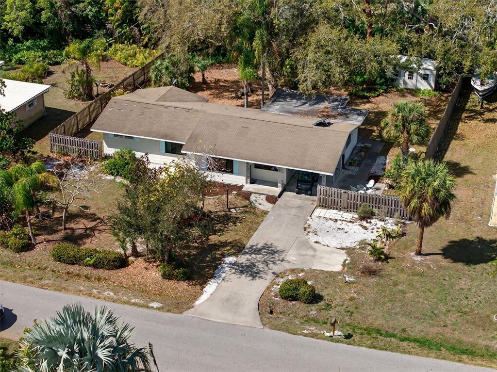 A single-story house features a covered carport with a golf cart and decorative metal columns — 6338 BEECHWOOD AVENUE, SARASOTA, FL