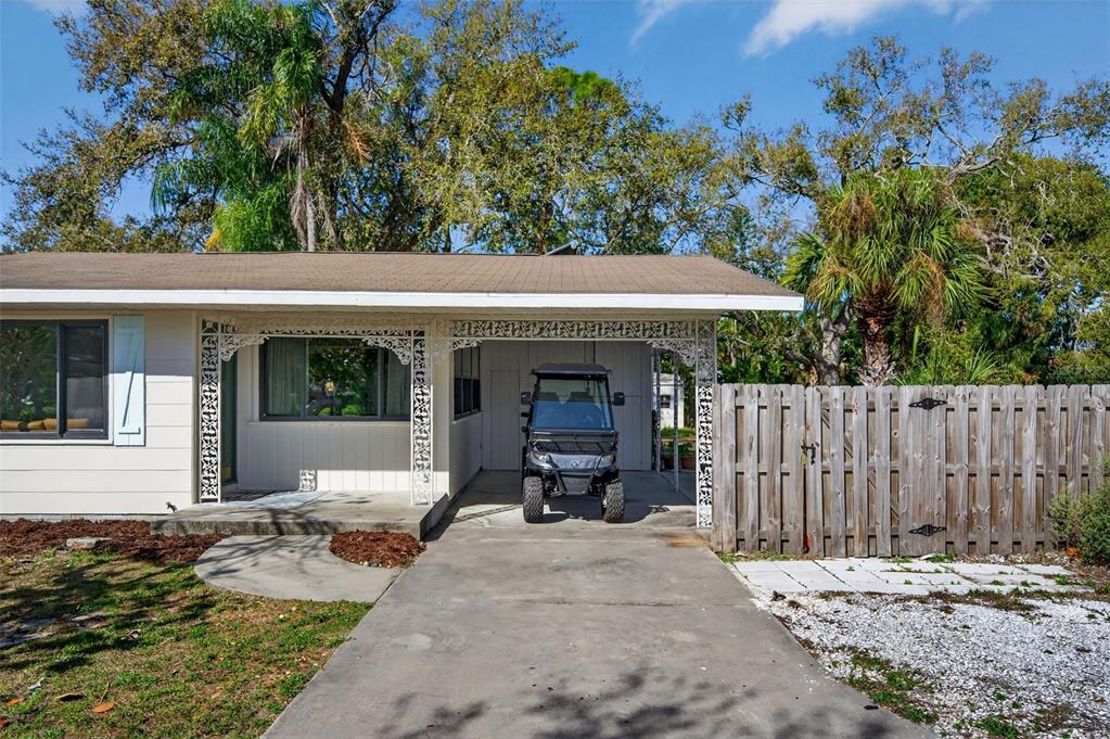 A teal front door with a brass knocker and mail slot sits under decorative ironwork — 6338 BEECHWOOD AVENUE, SARASOTA, FL