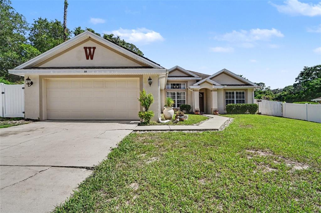 A single-story house with a beige exterior, a two-car garage, and a front walkway — 35 PLANTATION ROAD, DEBARY, FL