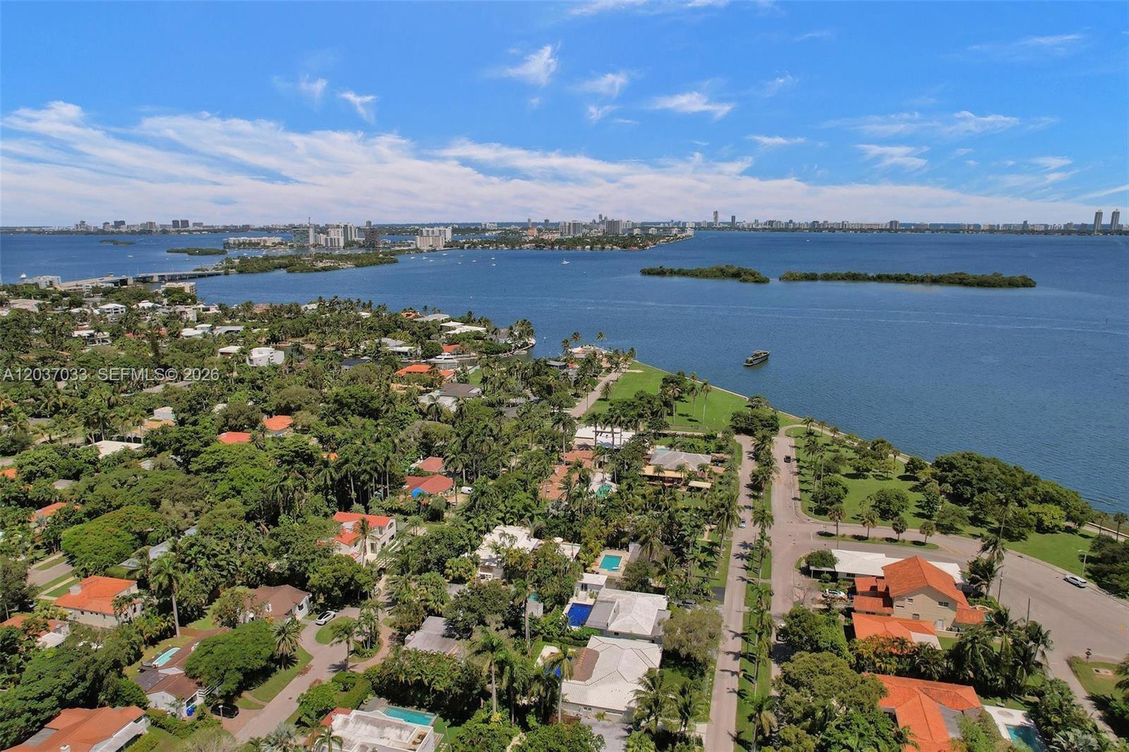 An aerial view shows a coastal residential neighborhood with lush trees and a large bay — 765 NE 70TH ST, Miami FL 33138, MIAMI, FL