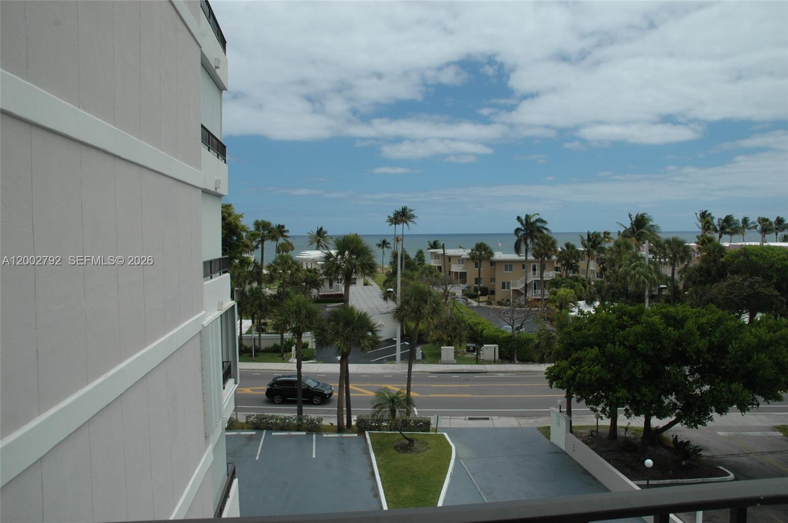An elevated view shows a street, palm trees, and the ocean beyond a building exterior — 1401 S Ocean Blvd # 408, Pompano Beach FL 33062, POMPANO BEACH, FL