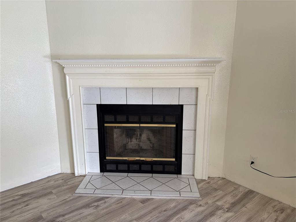 A white fireplace with a tile surround and hearth sits in the corner of a room — 14490 SE 80TH AVENUE, SUMMERFIELD, FL