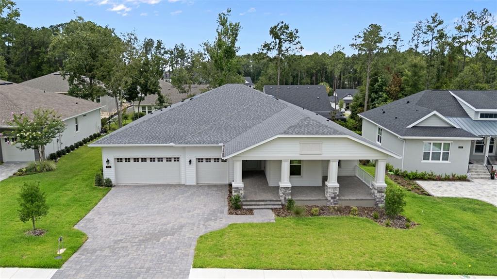 A single-story house with a gray shingled roof, white siding, and a paved driveway — 4538 MAJESTIC HILLS LOOP, BROOKSVILLE, FL