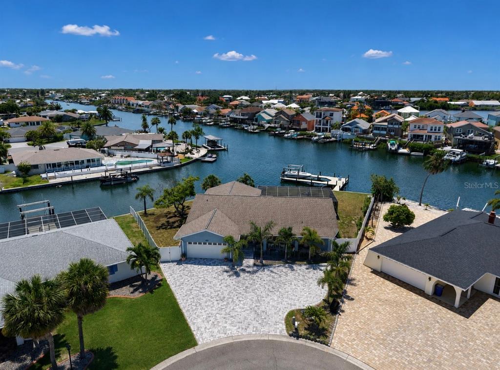 A single-story house with a large paver driveway and palm trees under a blue sky — 6301 COTTONWOOD LANE, APOLLO BEACH, FL
