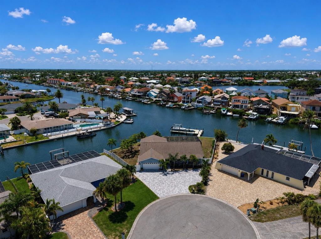 An aerial view shows three waterfront houses with boat docks along a canal in Florida — 6301 COTTONWOOD LANE, APOLLO BEACH, FL