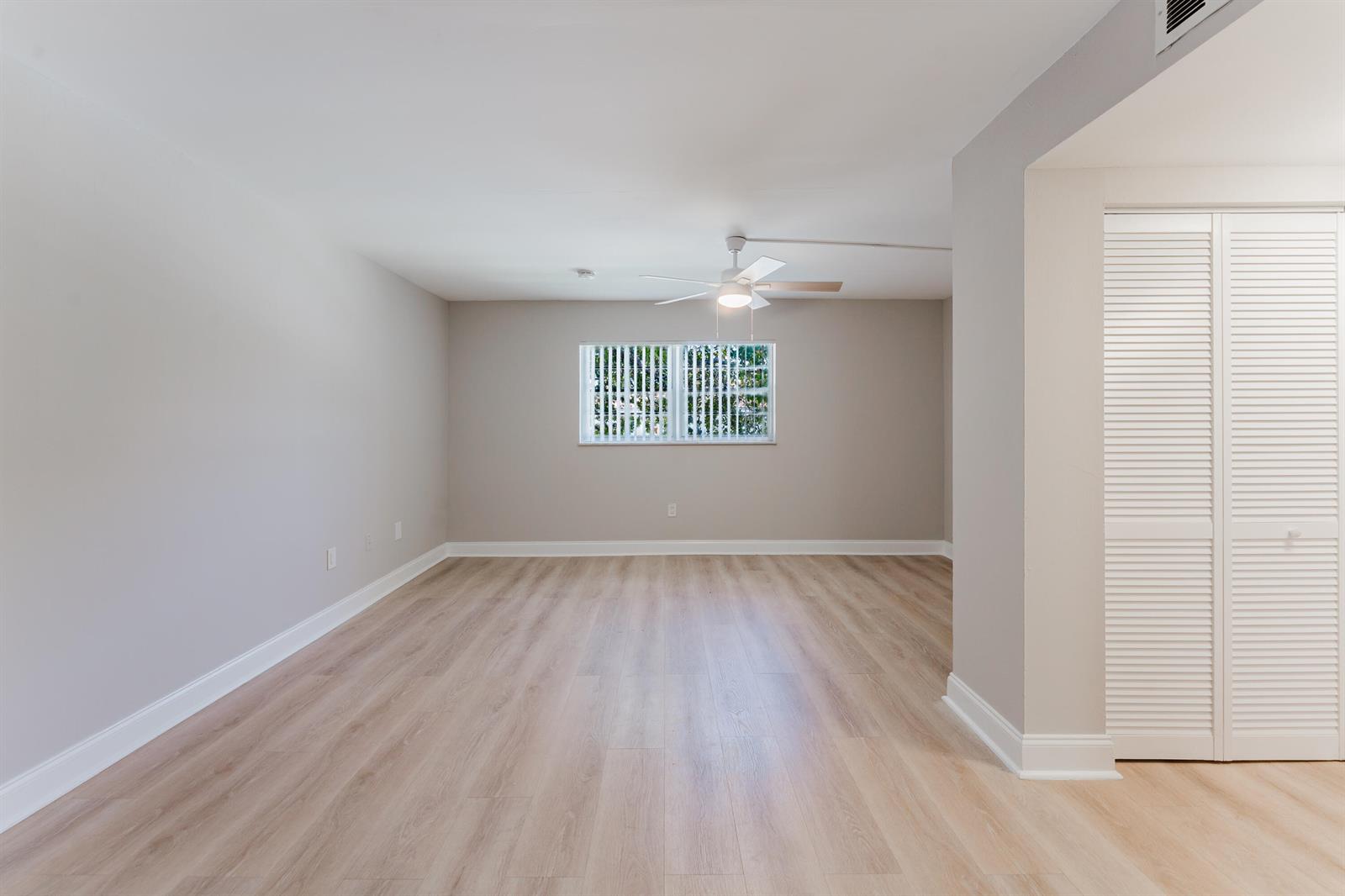 An empty room features light wood-look flooring, neutral walls, a ceiling fan, and louvered closet doors — 650 SW 2nd Avenue # 252, Boca Raton FL 33432, BOCA RATON, FL