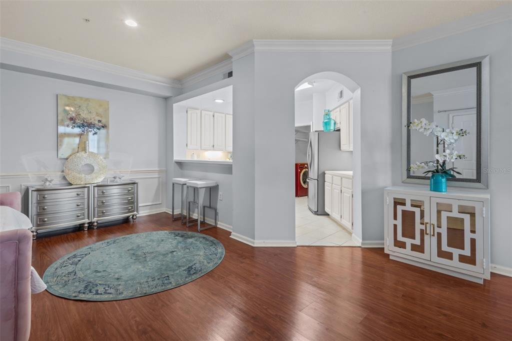 A room with wood flooring, a breakfast bar, and a white cabinet with a mirror — 3302 BAY CLUB CIRCLE UNIT 3202, TAMPA, FL