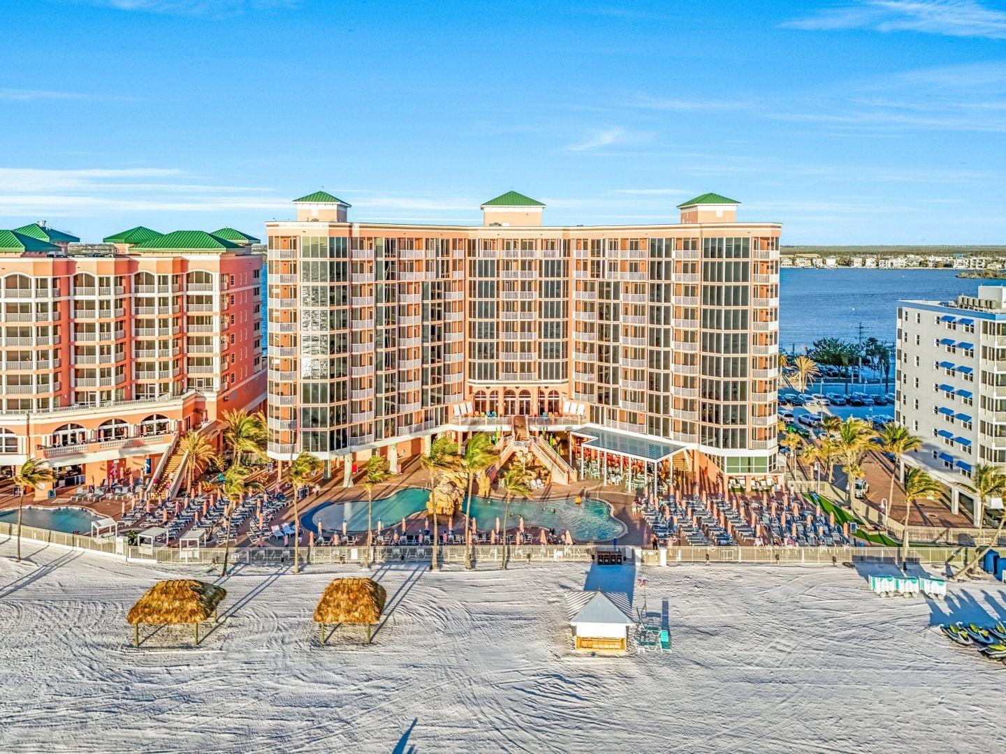 An aerial view of a large beachfront resort hotel with pools and lounge chairs — 200 Estero Boulevard # 207, FL 33931, FL