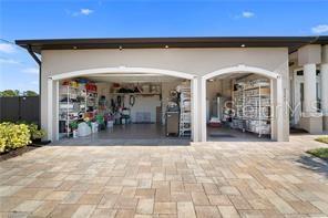 A tiled entryway leads through an arched doorway toward a living area with pool views — 2341 NW 36TH PLACE, CAPE CORAL, FL