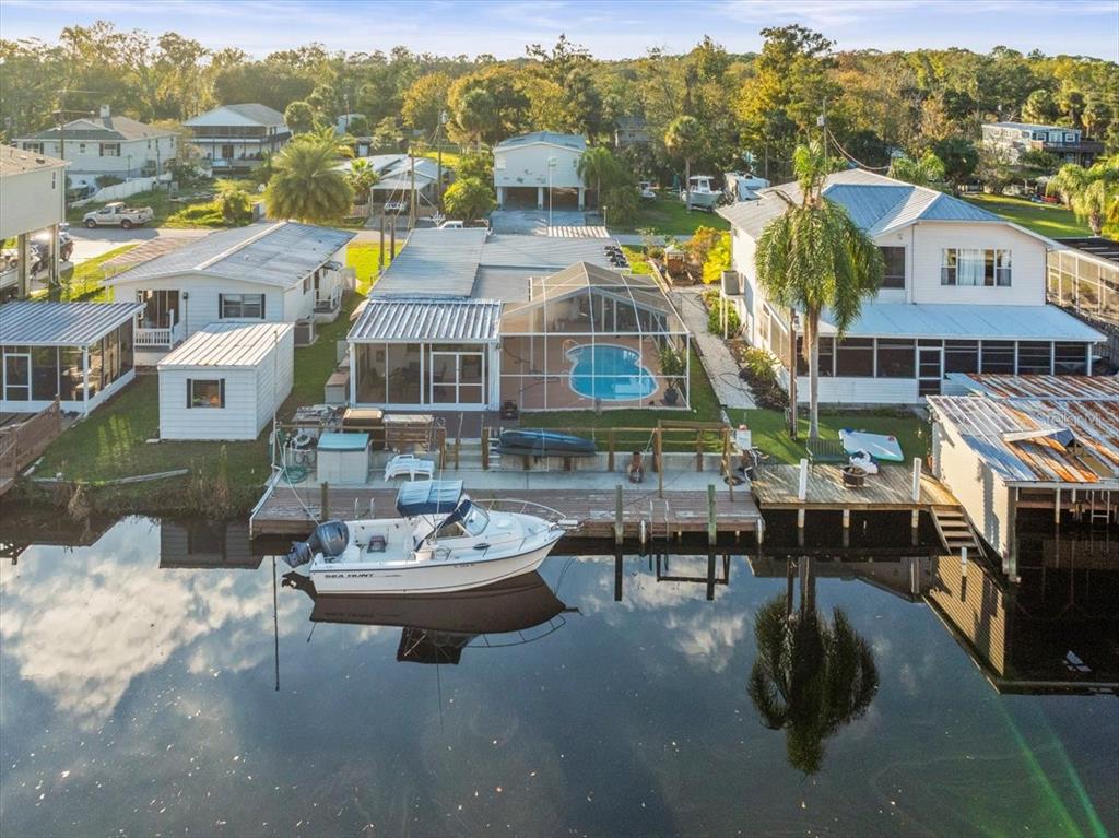 An aerial view of a waterfront house with a pool, boat dock, and parked boat — 7260 ABERDEEN COURT, WEEKI WACHEE, FL