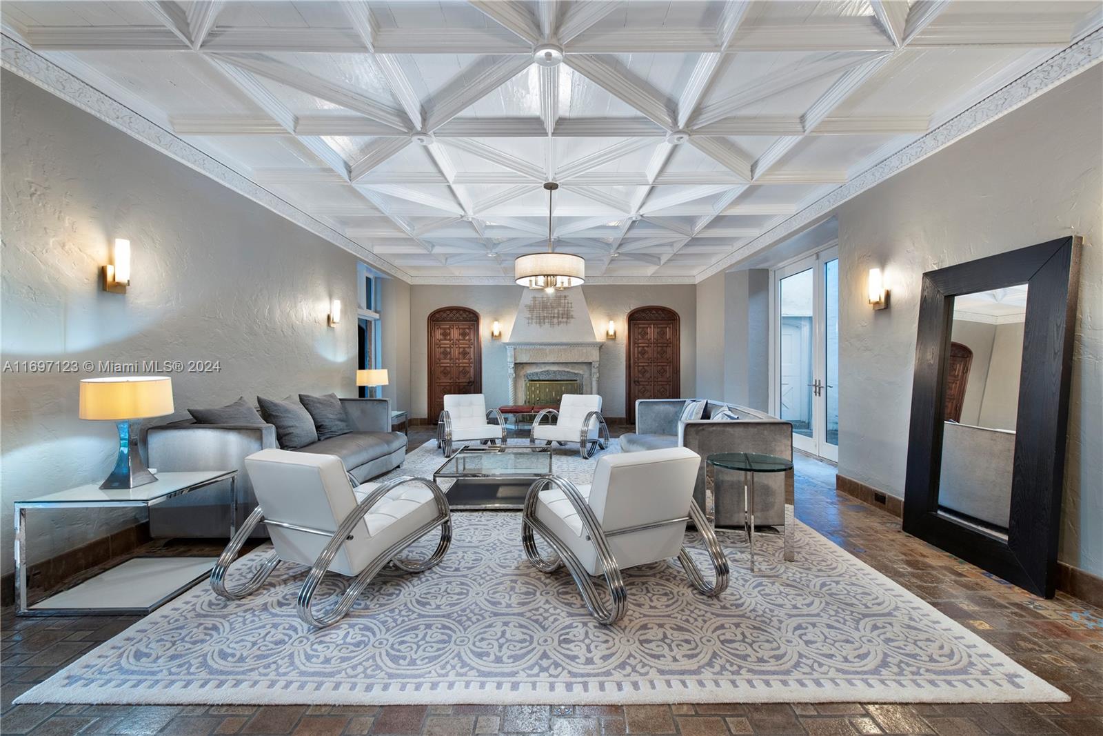 A living room features a geometric coffered ceiling, a stone fireplace, and modern white furniture — 4745 Pine Tree Dr, Miami Beach FL 33140, MIAMI BEACH, FL