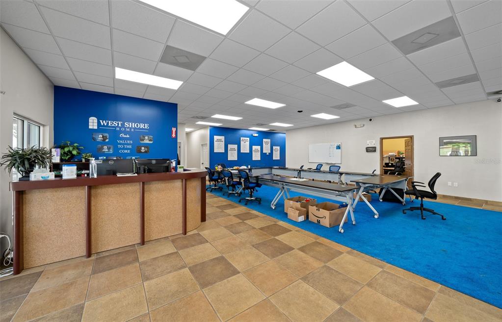 An office reception area features a curved front desk, blue carpeting, and a blue accent wall — 1720 NW 4TH AVENUE All Units, OCALA, FL