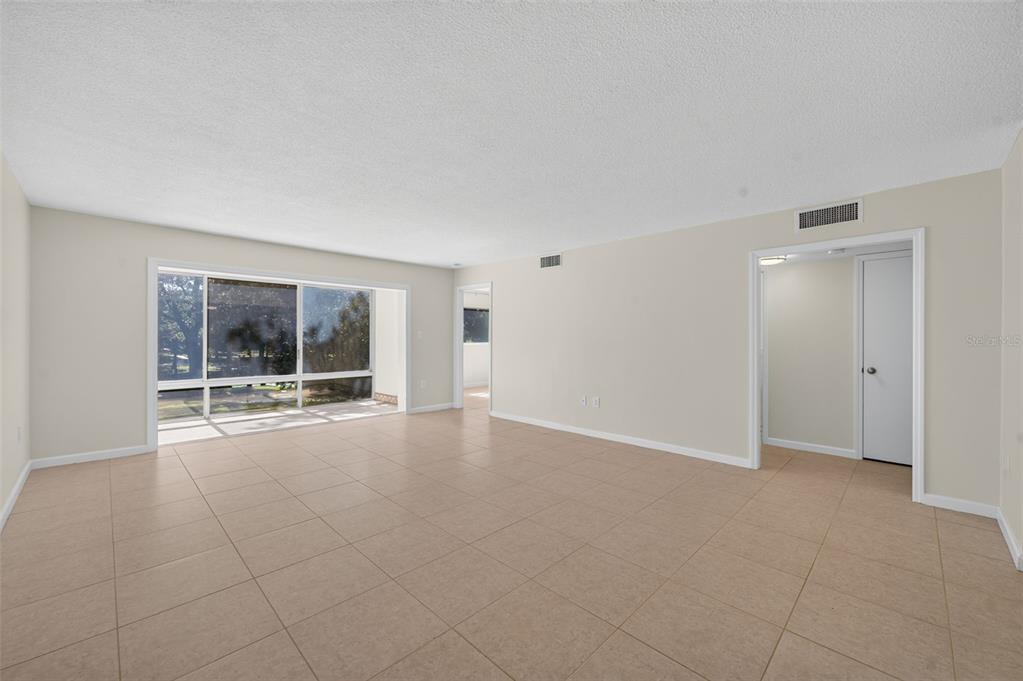 An empty room with beige tile flooring, white walls, and a large window — 700 MELROSE AVENUE UNIT A5, WINTER PARK, FL