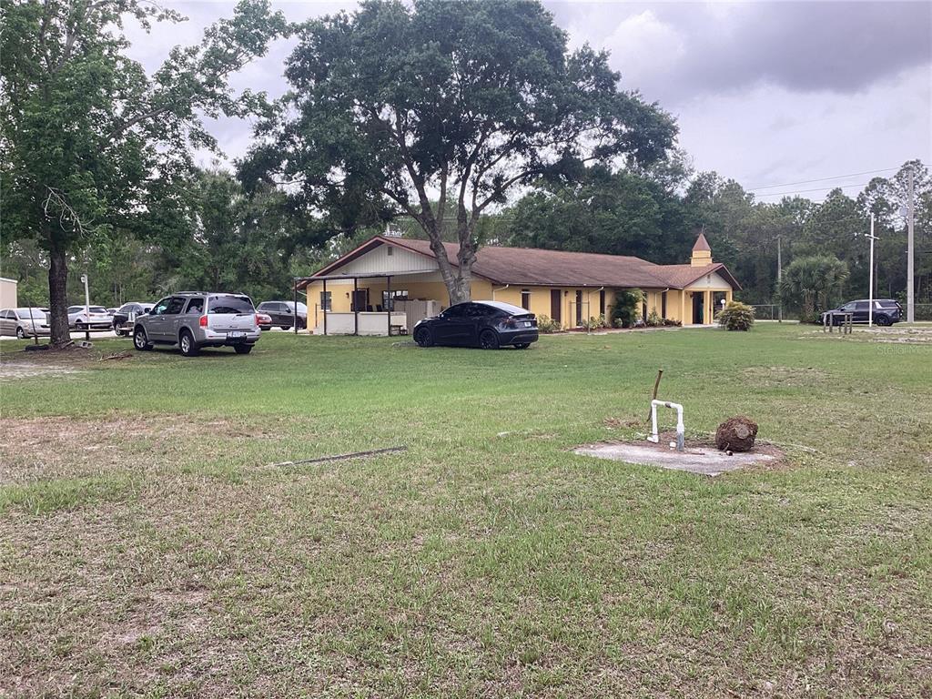 A low-slung, yellow building with a small steeple sits behind a large, grassy yard — 2270 JUPITER BLVD, PALM BAY, FL