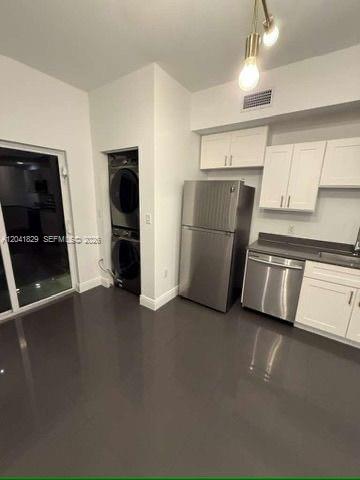 A kitchen with stainless steel appliances, white cabinets, and dark tile flooring — 5129 NW 5th Ave, Miami FL 33127, MIAMI, FL