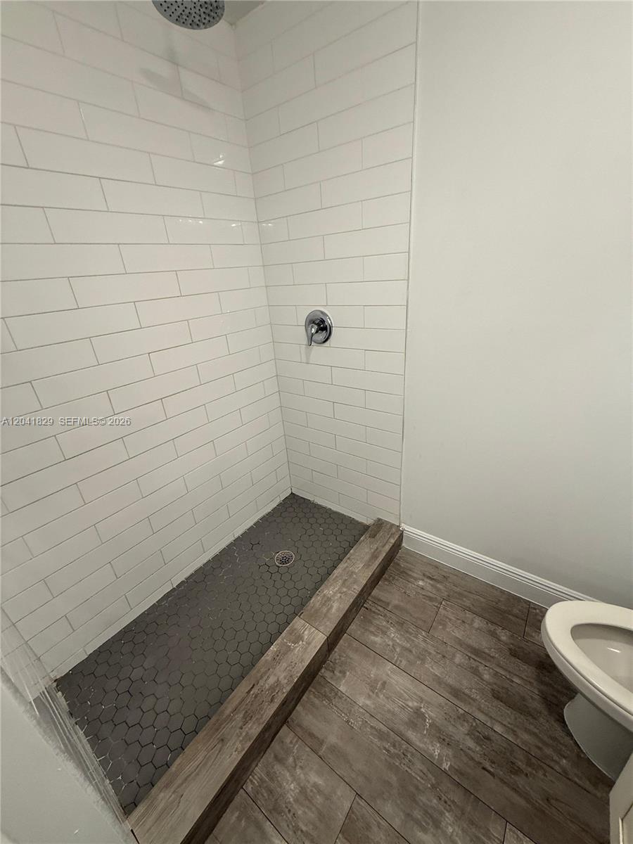 A bathroom features a white vanity, a toilet, and a shower-tub combo with subway tile — 5129 NW 5th Ave, Miami FL 33127, MIAMI, FL