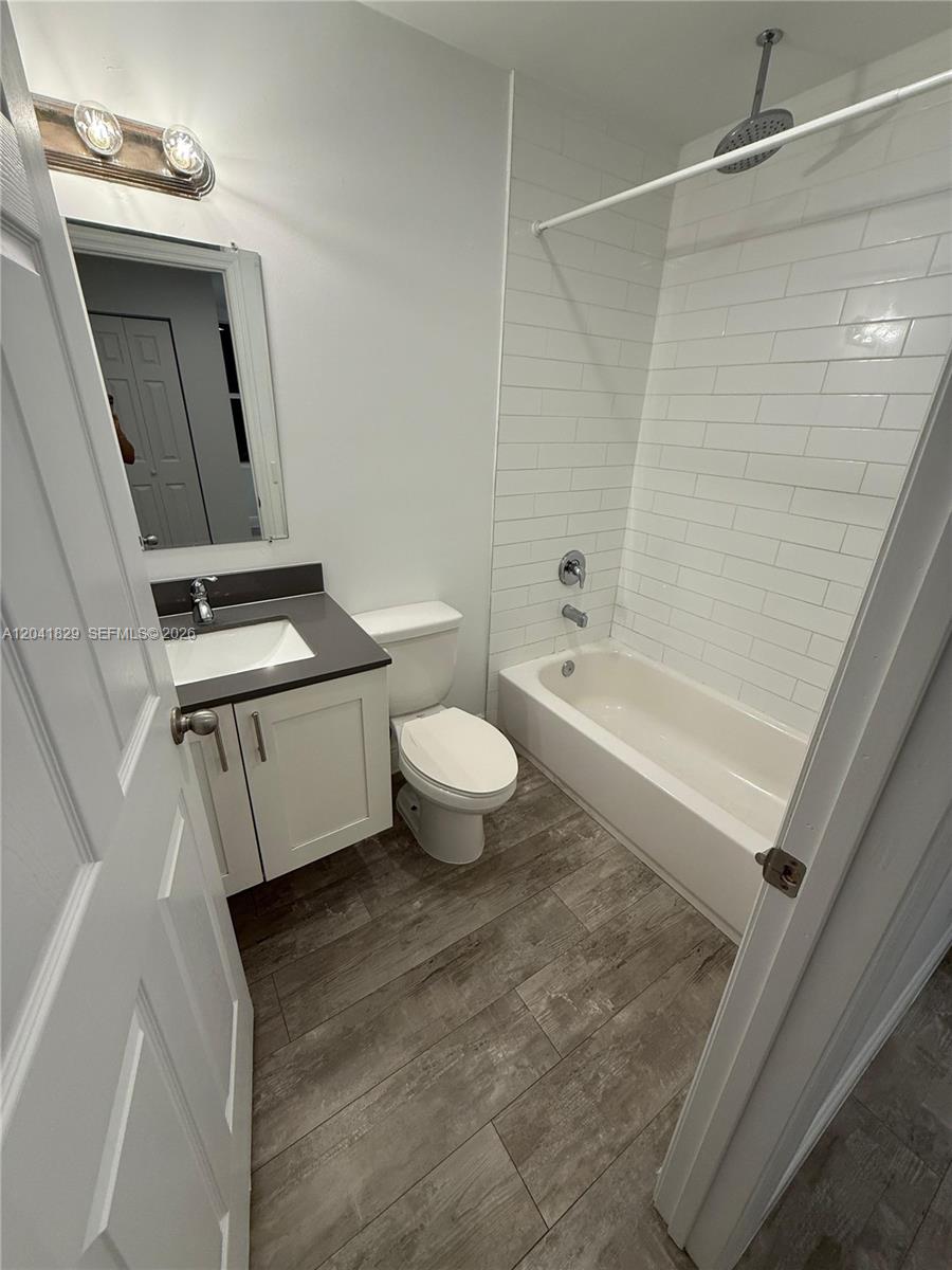 A bathroom features a white vanity, a toilet, and a bathtub with white subway tile — 5129 NW 5th Ave, Miami FL 33127, MIAMI, FL