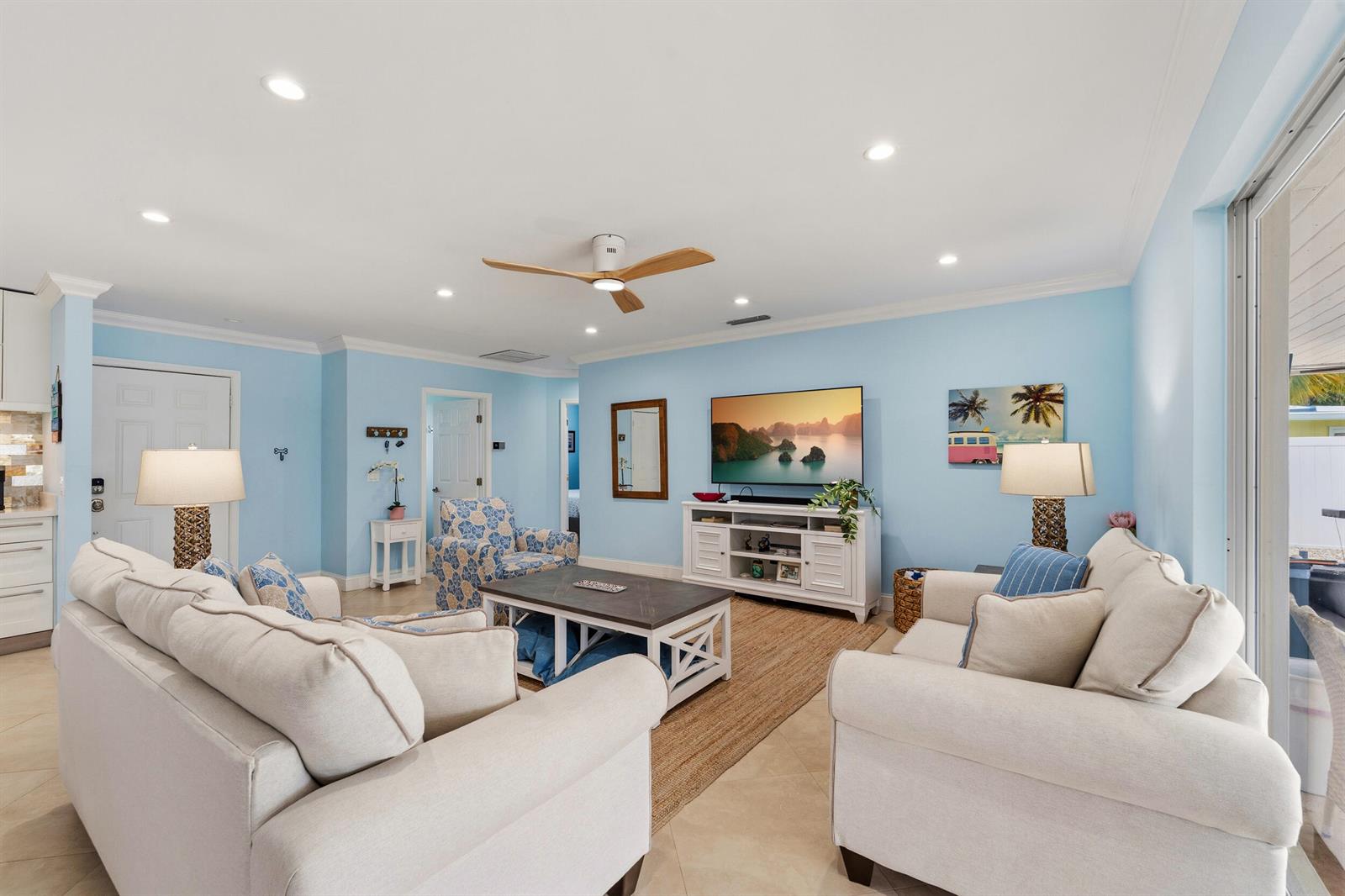 A living room with light blue walls, white sofas, a coffee table, and a television — 1205 Dolphin Road, Singer Island FL 33404, SINGER ISLAND, FL