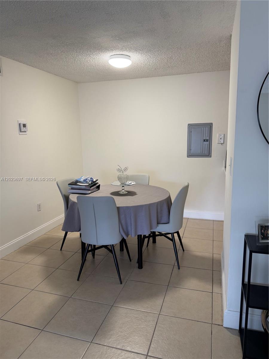 A dining area features a round table with four chairs on a tiled floor — 13789 SW 66th St # 283F, Miami FL 33183, MIAMI, FL
