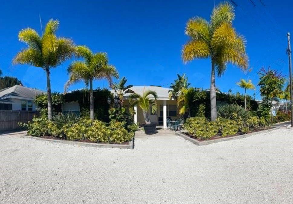 A single-story house with a gravel driveway and several palm trees in the front yard — 42 SOMERSET STREET, CLEARWATER BEACH, FL