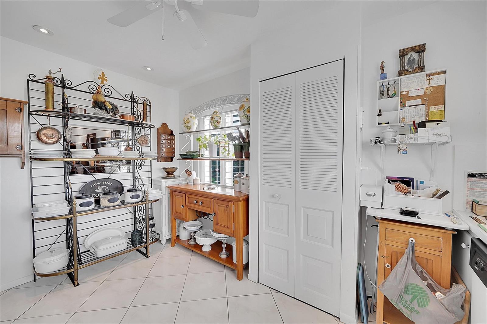 A kitchen area features a metal baker's rack, a wooden sideboard, and a white closet door — 9481 Sunrise Lakes Boulevard # 310, Sunrise FL 33322, SUNRISE, FL