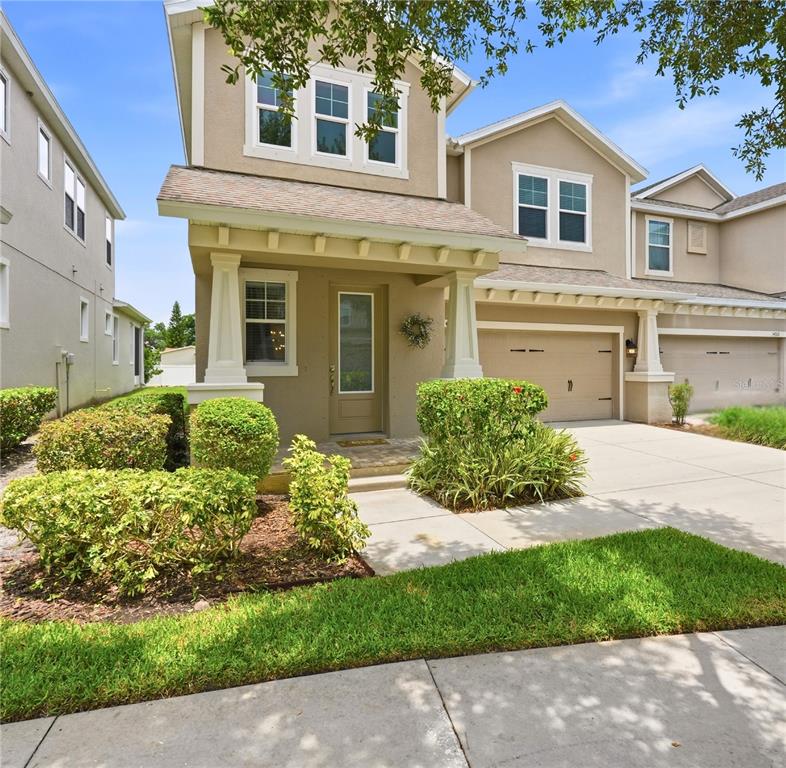 A two-story suburban house with a tan exterior, a front porch, and a two-car garage — 14508 ROCKY BROOK DRIVE, TAMPA, FL