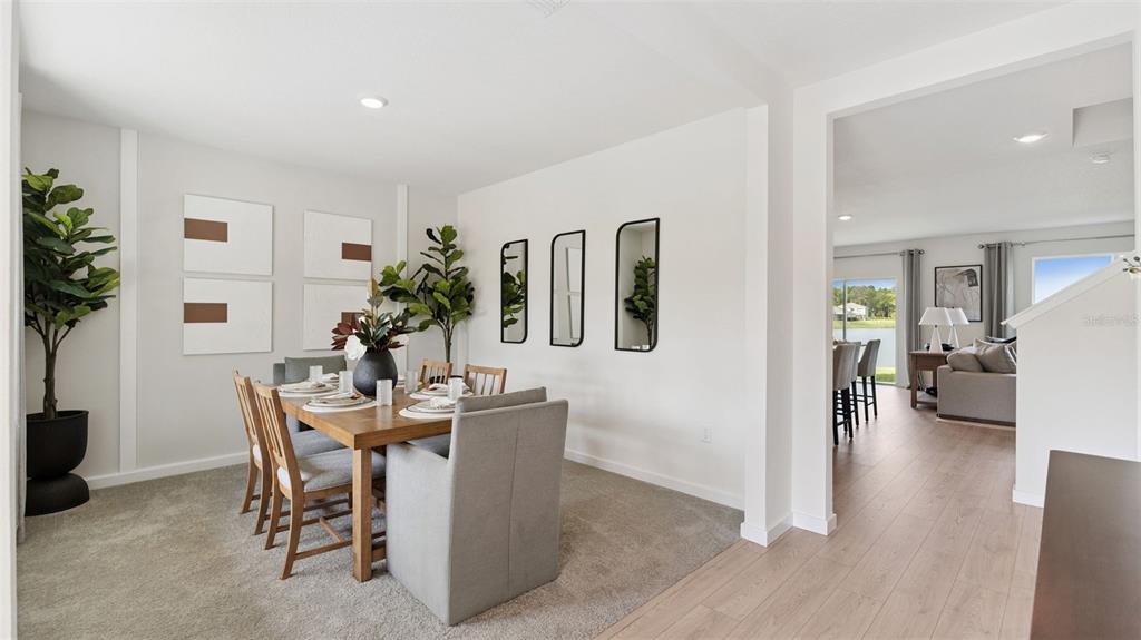 A dining room with a wooden table and chairs sits adjacent to a living area — 1126 GULL DRIVE, APOPKA, FL