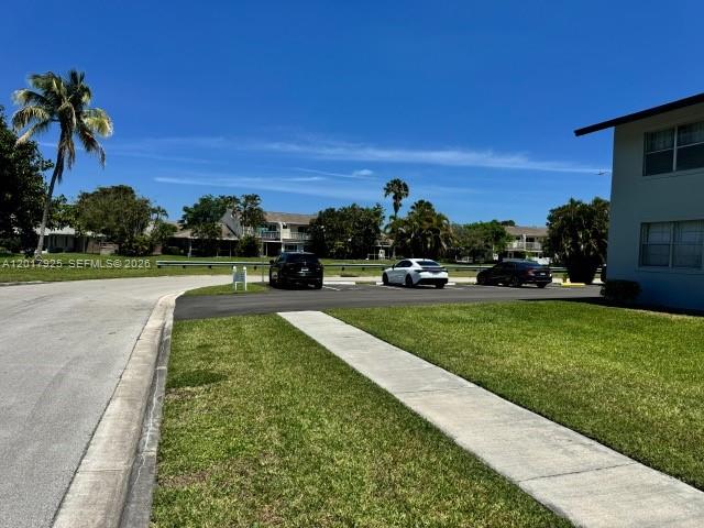 A paved road leads to a parking area with cars in front of residential buildings — 380 E Laurel Dr # 4D, Margate FL 33063, MARGATE, FL