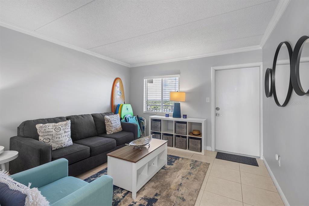 A living room features a gray sofa, a white coffee table, and a storage unit — 2401 S ATLANTIC AVENUE UNIT A603, NEW SMYRNA BEACH, FL