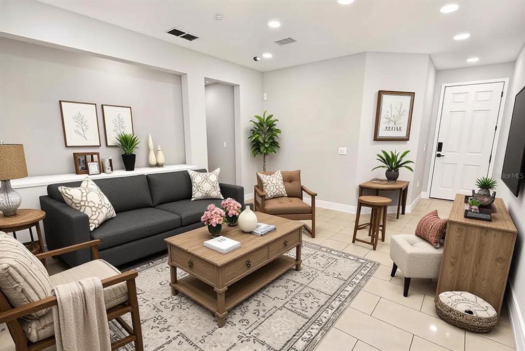 A living room features a grey sofa, wooden coffee table, armchairs, and neutral decor — 9644 SIMEON DRIVE, LAND O LAKES, FL