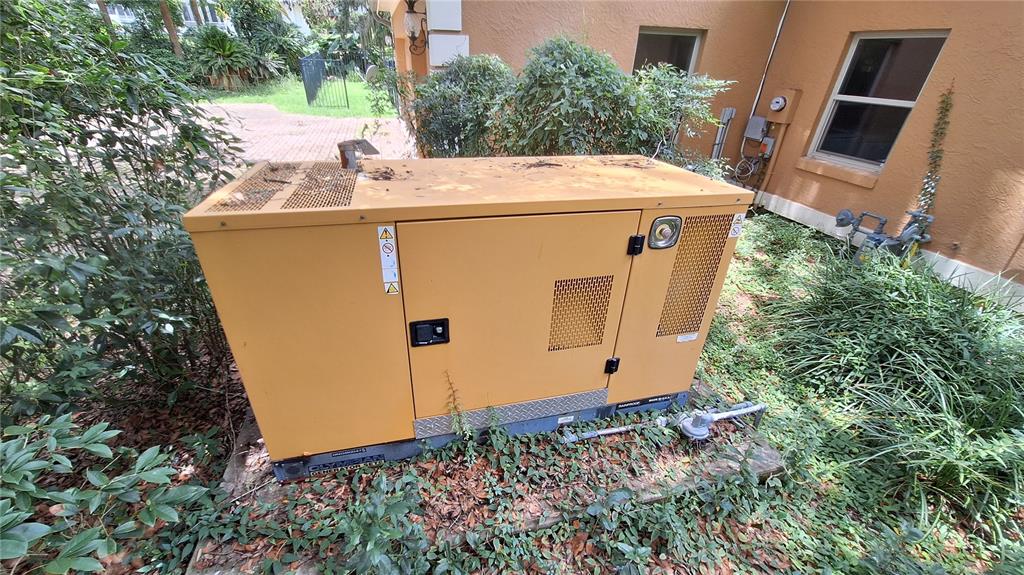 A yellow outdoor standby generator sits on a concrete pad next to a house — 2210 SE LAUREL RUN DRIVE, OCALA, FL