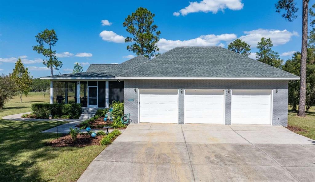 A gray brick house with a three-car garage and a screened-in porch — 1237 SW OLD LAKE CITY TERRACE, HIGH SPRINGS, FL