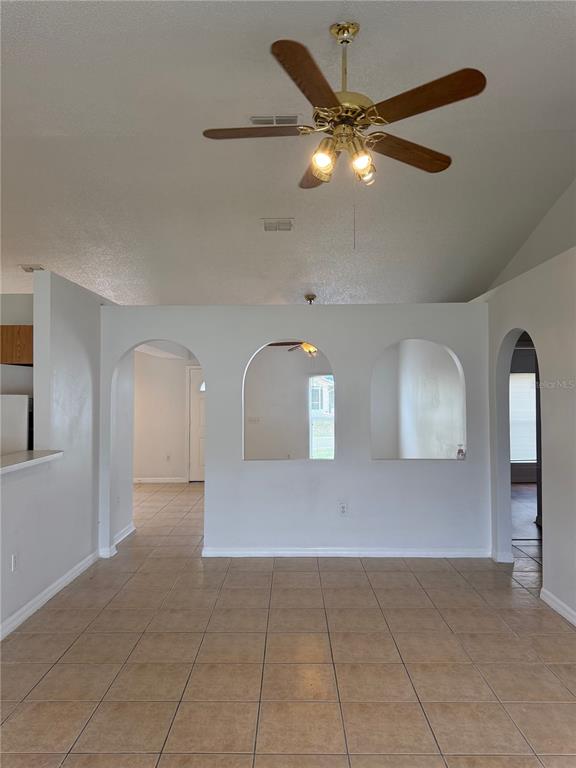 A room with tiled floors, a ceiling fan, and three arched openings in the wall — 405 FRANCISCO WAY, KISSIMMEE, FL