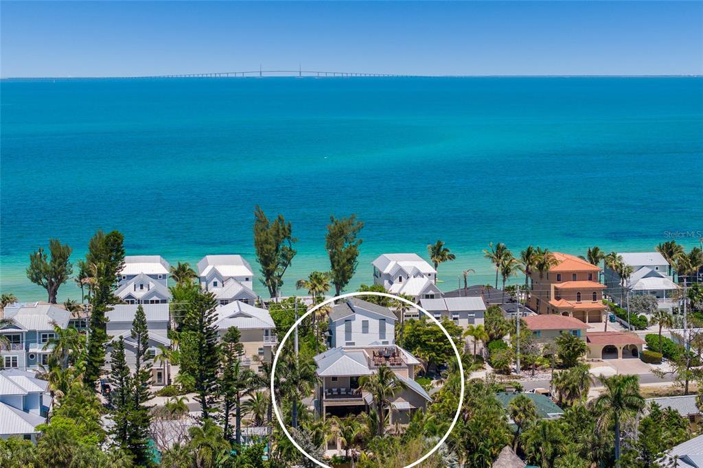 An aerial view shows a multi-story house circled in white near a turquoise ocean — 513 N BAY BOULEVARD, ANNA MARIA, FL