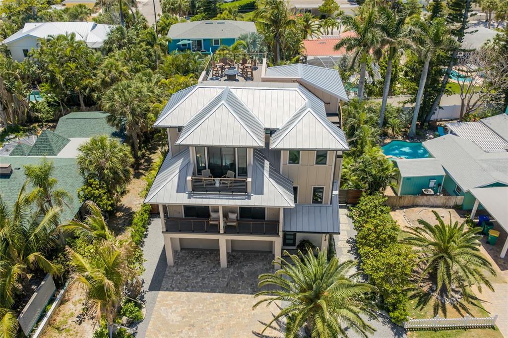 An aerial view shows a multi-story house with a metal roof and balconies — 513 N BAY BOULEVARD, ANNA MARIA, FL