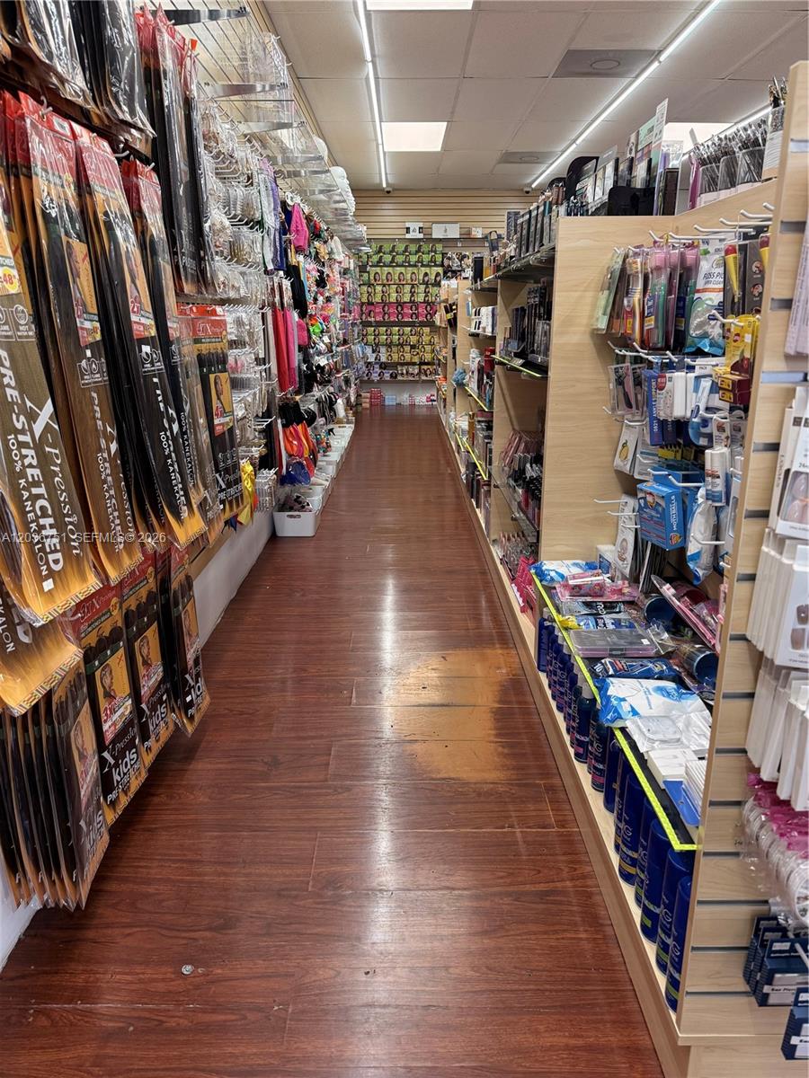 A narrow retail aisle features shelves stocked with hair extensions and beauty supplies on both sides — 715 NE 167th St, North Miami Beach FL 33162, NORTH MIAMI BEACH, FL