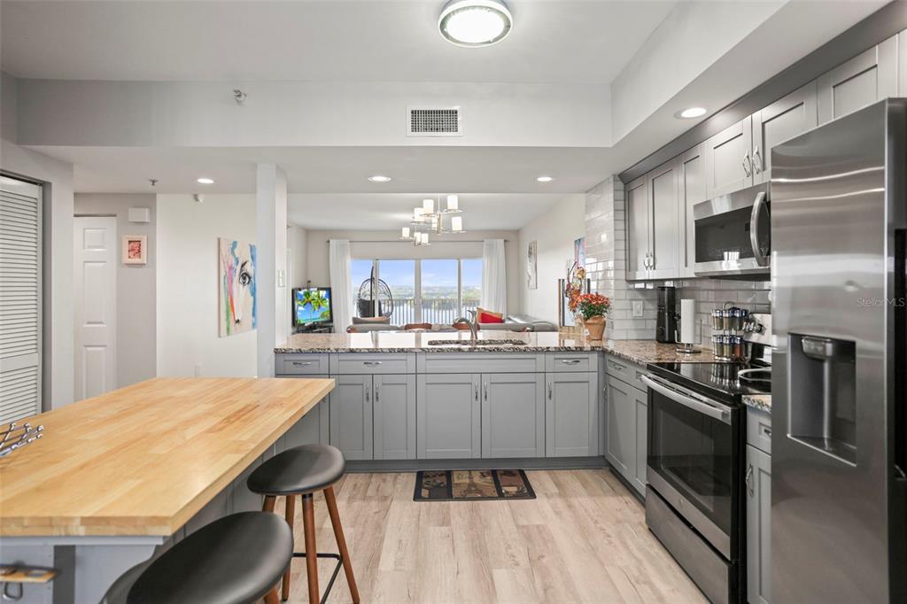 A kitchen with gray cabinets, stainless steel appliances, and a wooden island countertop — 6495 SHORELINE DRIVE UNIT 8502, ST PETERSBURG, FL