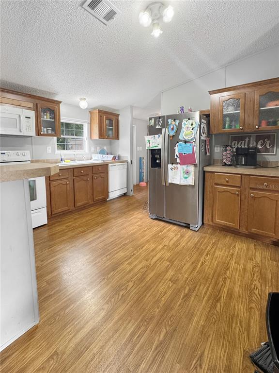A kitchen features wood cabinets, stainless steel appliances, and wood-look flooring — 1113 BIG OAK DRIVE, LAKE WALES, FL